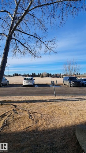 The property offers a clear view of an expansive open field, bordered by a distant treeline - 12 11265 31 Avenue, Edmonton, AB - Outdoor With View