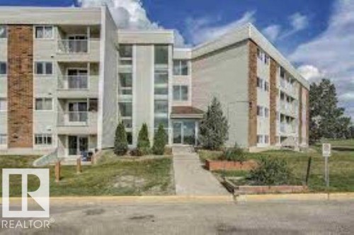 Exterior view of the property, showcasing its light-colored facade with brick accents and multiple balconies - 12 11265 31 Avenue, Edmonton, AB - Outdoor With Facade