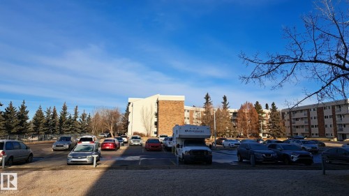 The property features multiple low-rise buildings with balconies, surrounded by mature trees - 12 11265 31 Avenue, Edmonton, AB - Outdoor