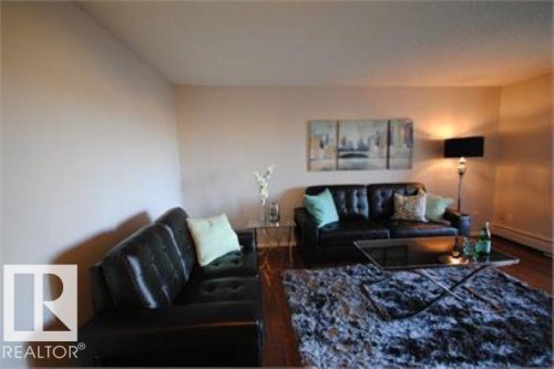 Living room featuring hardwood flooring, light-colored walls, and a dark plush rug - 12 11265 31 Avenue, Edmonton, AB - Indoor Photo Showing Living Room
