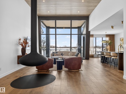 Living room with expansive windows and light wood finished floors - 7104 54 Avenue, Beaumont, AB - Indoor Photo Showing Living Room