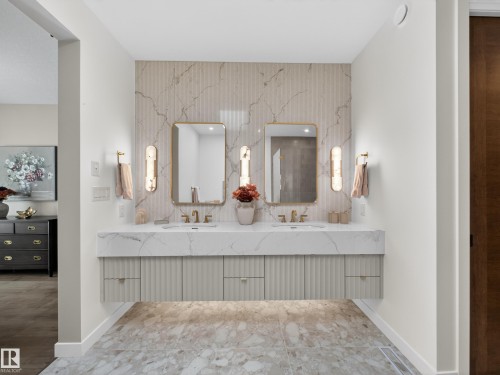 Full bathroom featuring an accent wall, double vanity, and marble finish floors - 7104 54 Avenue, Beaumont, AB - Indoor Photo Showing Bathroom