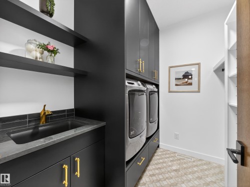 Laundry area with washing machine and dryer and cabinet space - 7104 54 Avenue, Beaumont, AB - Indoor Photo Showing Laundry Room