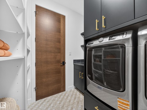 Laundry room with washer / clothes dryer, cabinet space, and light floors - 7104 54 Avenue, Beaumont, AB - Indoor Photo Showing Laundry Room