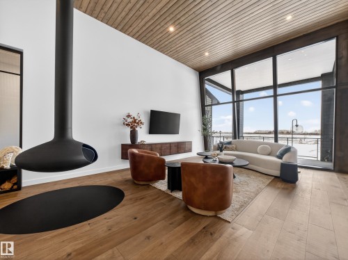 Living room with expansive windows, wood-type flooring, wood ceiling, and recessed lighting - 7104 54 Avenue, Beaumont, AB - Indoor
