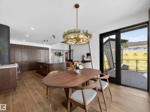 Dining space with light wood-style flooring and suspended lighting - 7104 54 Avenue, Beaumont, AB - Indoor Photo Showing Dining Room