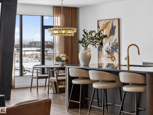 Dining area with light wood-style flooring and hanging lights - 7104 54 Avenue, Beaumont, AB - Indoor Photo Showing Dining Room