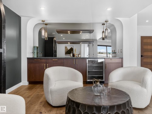 Sitting room with arched walkways, beverage cooler, light wood-type flooring, and recessed lighting - 7104 54 Avenue, Beaumont, AB - Indoor