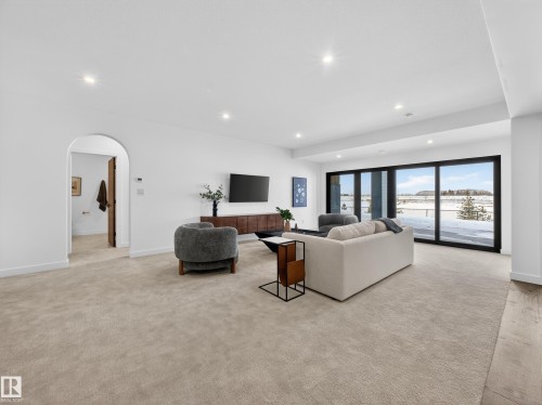 Living room with arched walkways, recessed lighting, and light carpet - 7104 54 Avenue, Beaumont, AB - Indoor