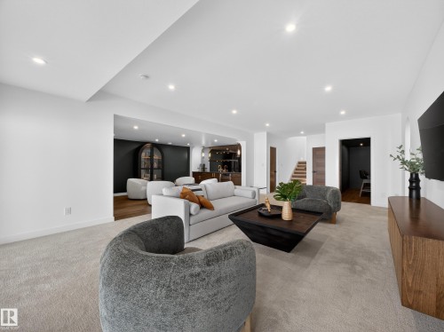 Living area featuring recessed lighting, light colored carpet, and bar - 7104 54 Avenue, Beaumont, AB - Indoor Photo Showing Living Room