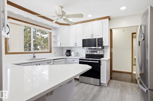 Kitchen featuring white cabinets, stainless steel appliances, light wood-style floors, a ceiling fan, and recessed lighting - 83 Bellevue Crescent, St. Albert, AB - Indoor Photo Showing Kitchen