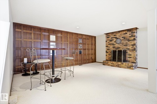 Living area featuring wood walls, carpet flooring, a fireplace, and recessed lighting - 83 Bellevue Crescent, St. Albert, AB - Indoor With Fireplace