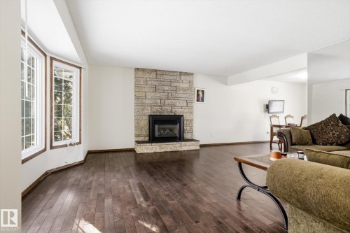 Living area featuring healthy amount of natural light, hardwood / wood-style floors, and a fireplace - 83 Bellevue Crescent, St. Albert, AB - Indoor Photo Showing Living Room With Fireplace