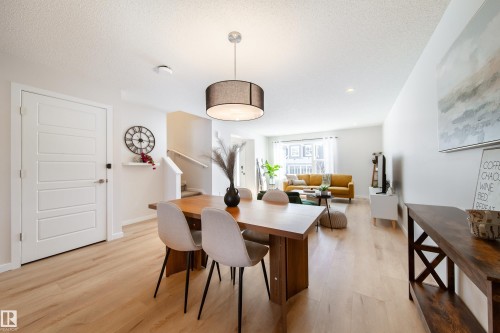 Dining space featuring light wood finished floors and a textured ceiling - 112 Stonehouse Way, Leduc, AB - Indoor Photo Showing Dining Room