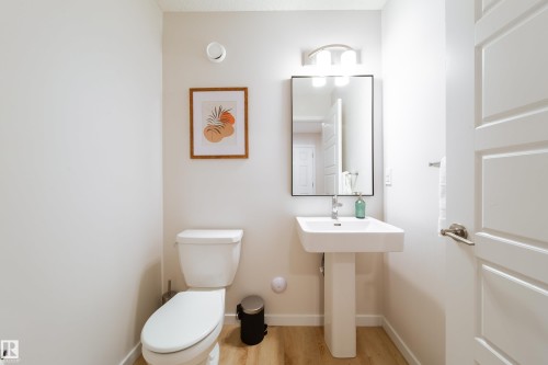 Bathroom with toilet and light wood-type flooring - 112 Stonehouse Way, Leduc, AB - Indoor Photo Showing Bathroom