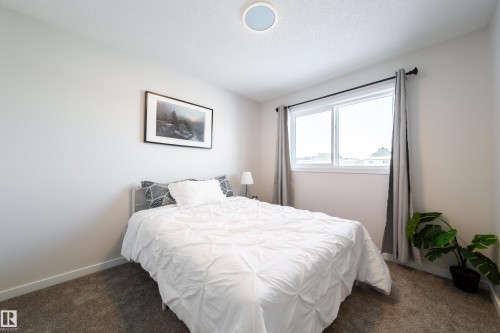 Bedroom featuring dark carpet and baseboards - 112 Stonehouse Way, Leduc, AB - Indoor Photo Showing Bedroom