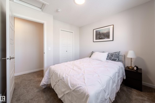 Bedroom with dark colored carpet and a closet - 112 Stonehouse Way, Leduc, AB - Indoor Photo Showing Bedroom