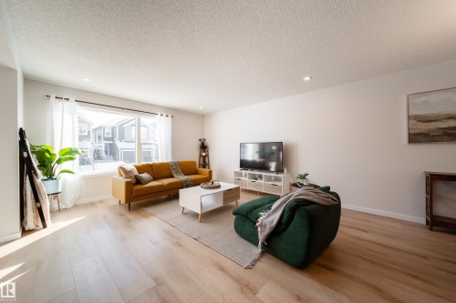 Living room with light wood-type flooring, a textured ceiling, and recessed lighting - 112 Stonehouse Way, Leduc, AB - Indoor Photo Showing Living Room