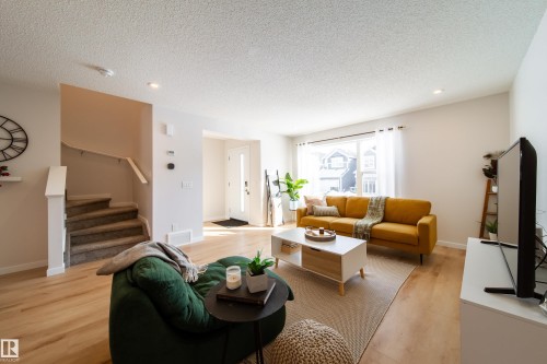 Living area featuring light wood finished floors, recessed lighting, and a textured ceiling - 112 Stonehouse Way, Leduc, AB - Indoor Photo Showing Living Room