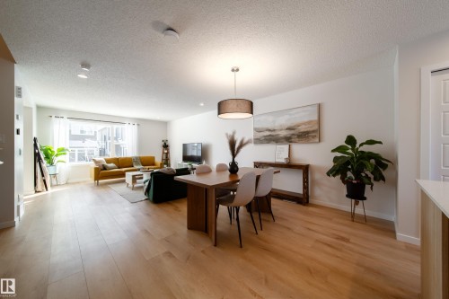 Dining area with a textured ceiling and light wood-type flooring - 112 Stonehouse Way, Leduc, AB - Indoor