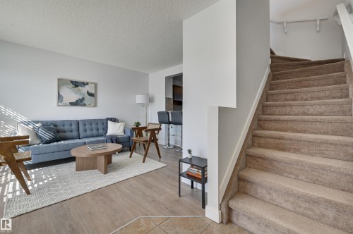 Stairway with a textured ceiling and wood finished floors - 21 6032 38 Avenue, Edmonton, AB - Indoor Photo Showing Other Room
