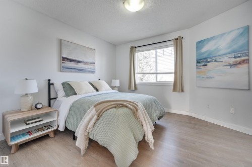 Bedroom with light wood-type flooring and a textured ceiling - 21 6032 38 Avenue, Edmonton, AB - Indoor Photo Showing Bedroom