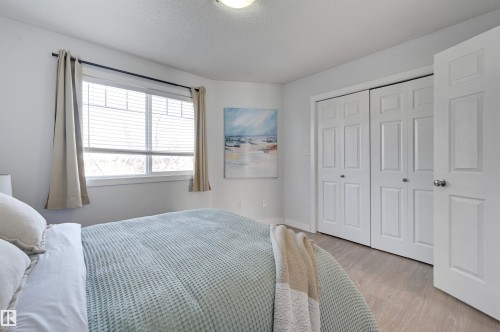 Bedroom with light wood-style flooring, a closet, and a textured ceiling - 21 6032 38 Avenue, Edmonton, AB - Indoor Photo Showing Bedroom