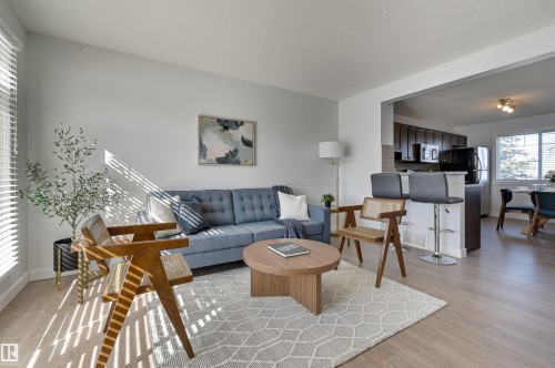 Living room featuring light wood-style flooring and a textured ceiling - 21 6032 38 Avenue, Edmonton, AB - Indoor Photo Showing Living Room