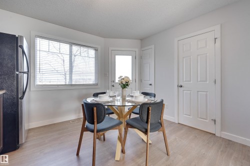 Dining area featuring light wood-type flooring and a textured ceiling - 21 6032 38 Avenue, Edmonton, AB - Indoor Photo Showing Other Room