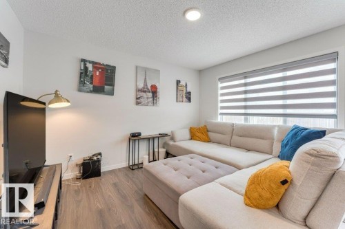 Living area with wood finished floors and a textured ceiling - 1323 South Creek Link, Stony Plain, AB - Indoor