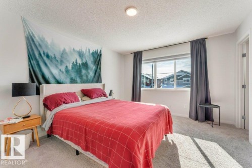 Bedroom featuring light carpet and a textured ceiling - 1323 South Creek Link, Stony Plain, AB - Indoor Photo Showing Bedroom