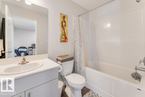 Bathroom with vanity, shower / tub combo, ensuite bath, and wood finished floors - 1323 South Creek Link, Stony Plain, AB - Indoor Photo Showing Bathroom