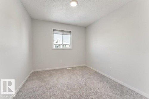 Room featuring light gray carpeting, white walls, and a window with blinds - 1323 South Creek Link, Stony Plain, AB - Indoor Photo Showing Other Room