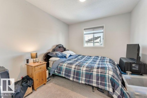Bedroom featuring light carpet and a textured ceiling - 1323 South Creek Link, Stony Plain, AB - Indoor Photo Showing Bedroom