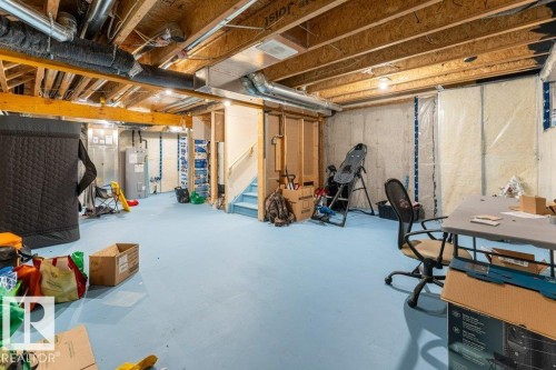 Unfinished below grade area with stairway and water heater - 1323 South Creek Link, Stony Plain, AB - Indoor Photo Showing Basement