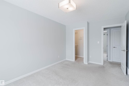This room features light grey walls, carpeted flooring, and a ceiling light fixture - 326 Desrochers Boulevard, Edmonton, AB - Indoor Photo Showing Other Room