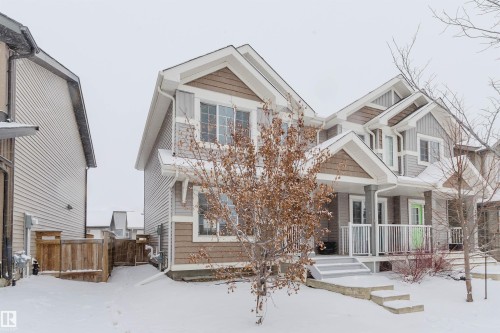 The property features a two-story design with light gray siding and brown shake accents - 326 Desrochers Boulevard, Edmonton, AB - Outdoor With Facade