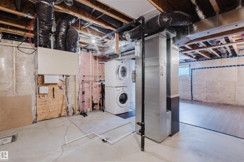 Utility area featuring a washer and dryer, exposed ceiling joists, and ductwork - 326 Desrochers Boulevard, Edmonton, AB - Indoor Photo Showing Basement