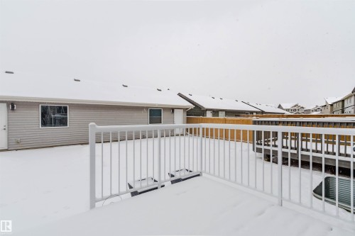 The property features a spacious rear yard with a snow-covered ground and a white railing - 326 Desrochers Boulevard, Edmonton, AB - Outdoor With Exterior