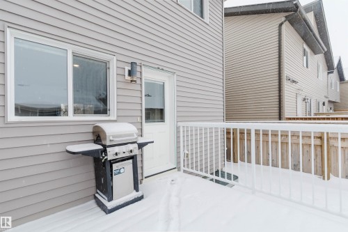 The property features a private deck with white railings and a wooden fence - 326 Desrochers Boulevard, Edmonton, AB - Outdoor With Exterior