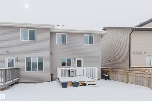 The property features a private deck with white railings and an outdoor light fixture, accessible via a glass-paneled door - 326 Desrochers Boulevard, Edmonton, AB - Outdoor With Exterior
