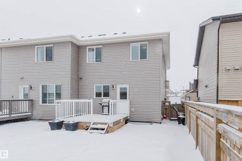The property features a private backyard with a spacious wooden deck, complete with white railings, offering outdoor living space - 326 Desrochers Boulevard, Edmonton, AB - Outdoor With Exterior