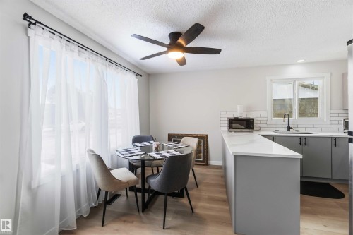 Dining room with light wood-style flooring, a ceiling fan, and a textured ceiling - 4615 49 Avenue, Redwater, AB - Indoor