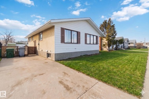 Exterior featuring white siding, stucco finish, and a concrete driveway - 4615 49 Avenue, Redwater, AB - Outdoor With Exterior