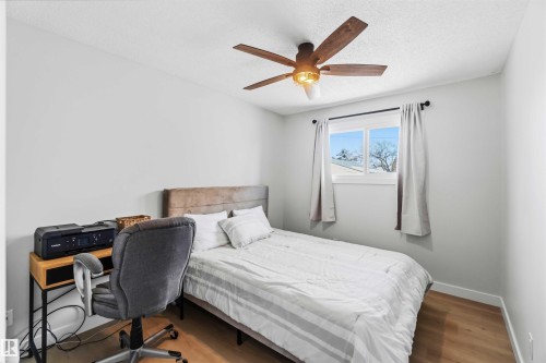 Bedroom featuring light wood-style floors, a ceiling fan, a desk, and a textured ceiling - 4615 49 Avenue, Redwater, AB - Indoor Photo Showing Bedroom