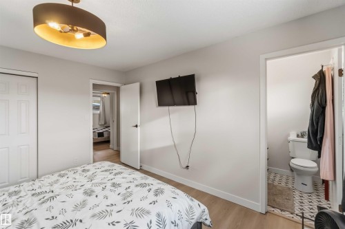 Bedroom featuring a closet, light wood-style flooring, and connected bathroom - 4615 49 Avenue, Redwater, AB - Indoor Photo Showing Bedroom