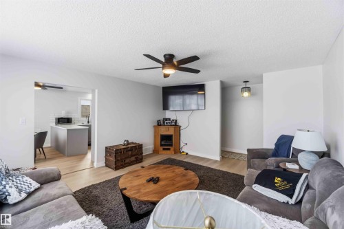 Living room featuring ceiling fan, light wood finished floors, and a textured ceiling - 4615 49 Avenue, Redwater, AB - Indoor Photo Showing Living Room