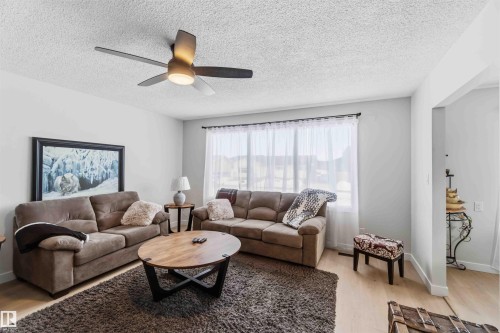 Living room with light wood-style flooring, a textured ceiling, and ceiling fan - 4615 49 Avenue, Redwater, AB - Indoor Photo Showing Living Room