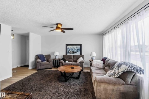 Living room with light wood-type flooring, ceiling fan, and a textured ceiling - 4615 49 Avenue, Redwater, AB - Indoor Photo Showing Living Room
