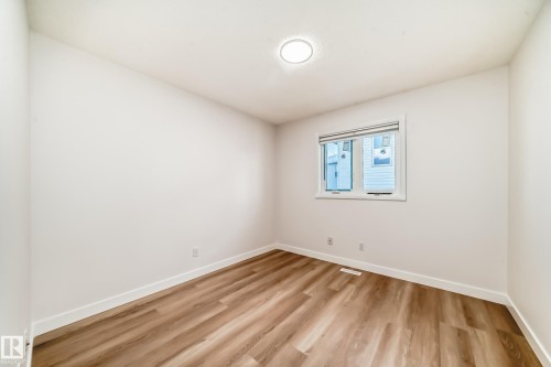 Unfurnished room featuring light wood-style floors and baseboards - 14063 128 Street, Edmonton, AB - Indoor Photo Showing Other Room
